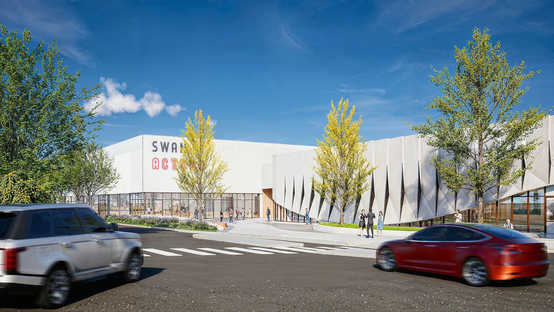 Street approach to Swan Active leisure centre, its folded white facade behind young trees